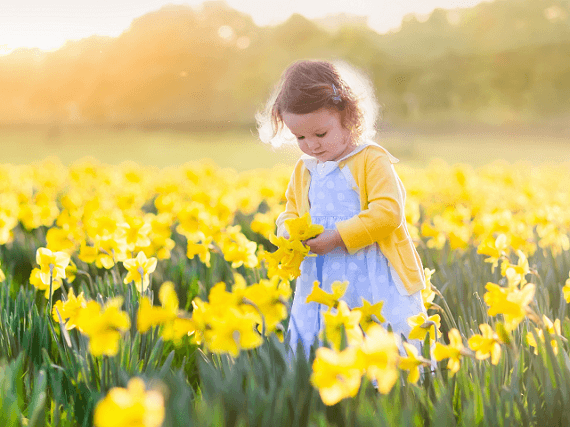 Malé dievčatko medzi kvetmi na lúke